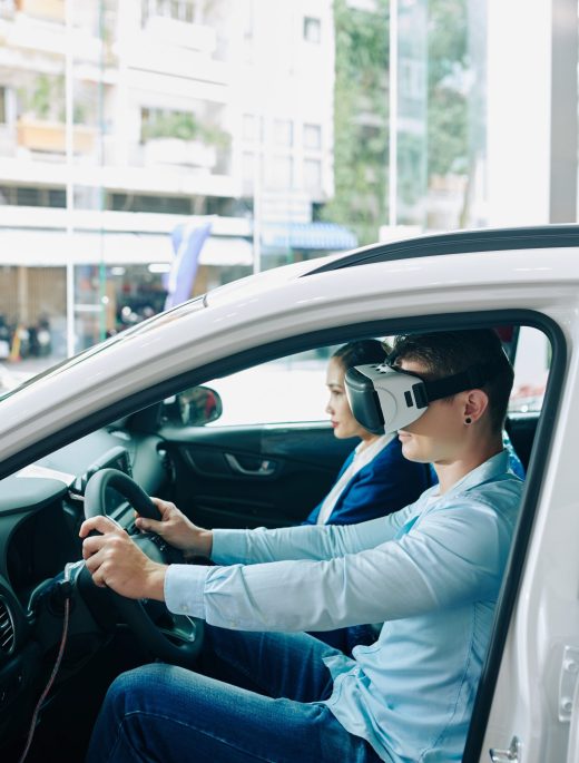 Virtual reality test drive Young man wearing virtual reality helmet when taking car for test drive